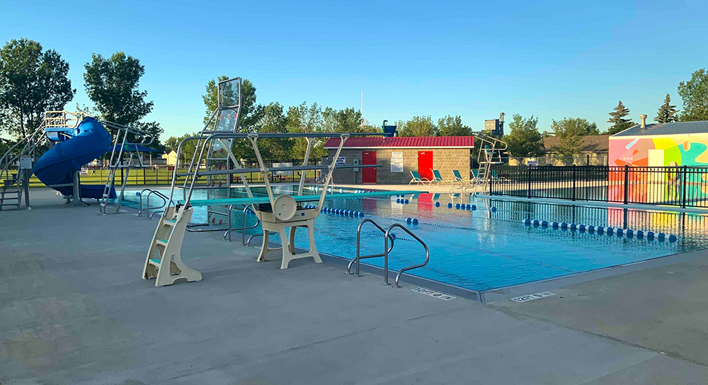 Crosby Swimming Pool's lap area with a diving board and water slide